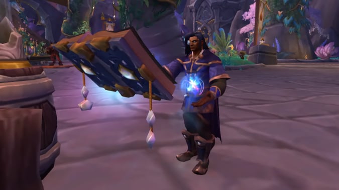 A man with dark blue hair and a monocle casts a spell from a floating book.