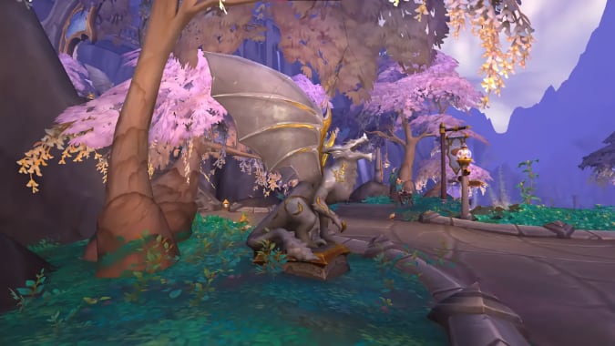 A roaring dragon statue sits among pink and green foliage.