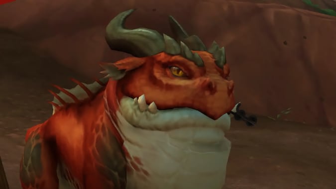 A horned red frog monster holds a tiny pair of sunglasses in its mouth.